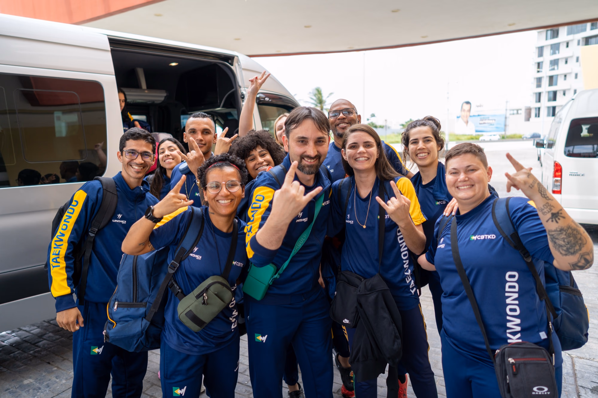 Delegación deportiva brasileña posando junto a su unidad de Serénvia